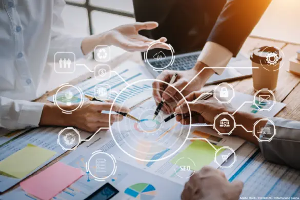 Team analysiert Projektdaten und Diagramme als Symbol für Agiles Arbeiten, effiziente Zusammenarbeit und flexible Entscheidungsprozesse im Unternehmen.